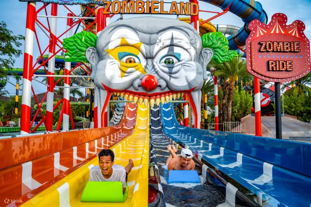 Two young men having fun on the thrilling Zombieland ride water slide at Columbia Pictures Aquaverse theme park in Pattaya.