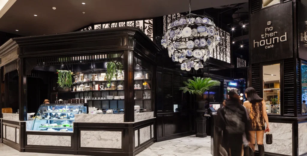 Chic black modern storefront of Another Hound Cafe on the G floor featuring an iconic chandelier made of decorative ceramic plates.